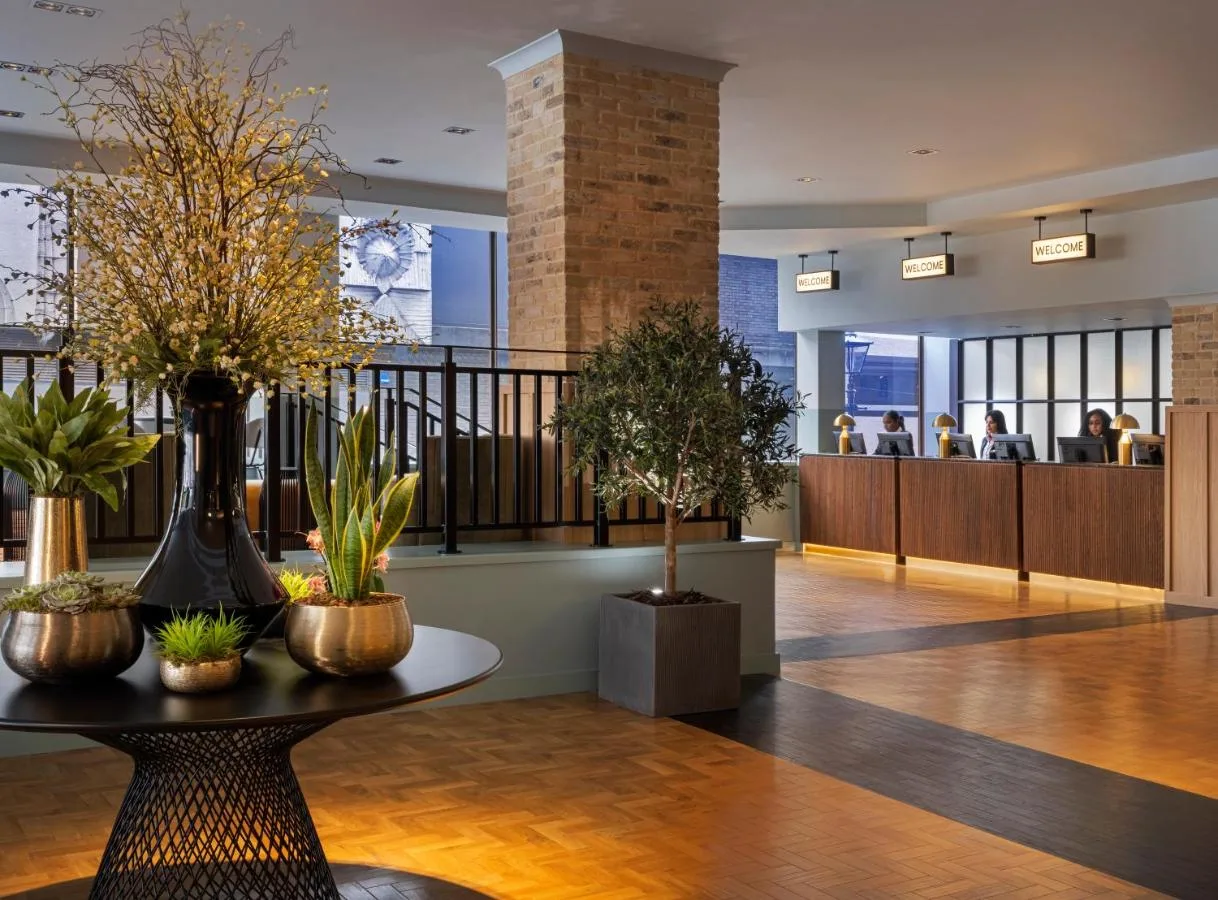 Lobby with tables and potted plants at the Broad Street hotel